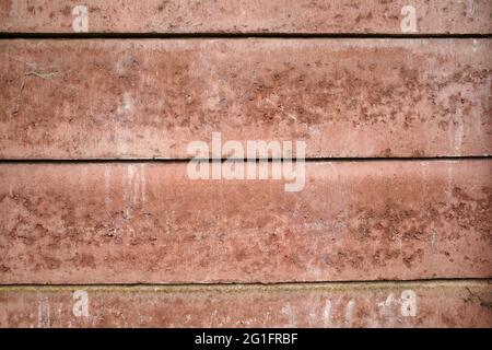 Part of a concrete fence which is losing it's terracotta color. Meant as background. Stock Photo