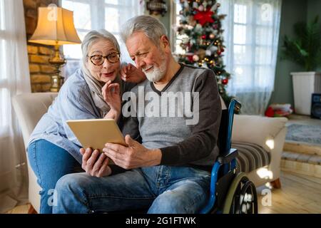 Senior couple having fun and laughing while using their tablet pc computer. Stock Photo