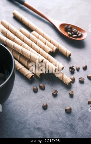 wafer roll chocolate , coffee beans and coffee mug on table , Stock Photo