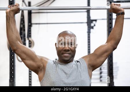 Portrait of African American bodybuilder doing physical effort in gym. Hard workout. Stock Photo