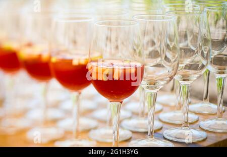 several wine glasses ,some filled with red cocktail and some empty Stock Photo