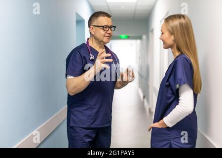 Two doctors discussing diagnosis while walking Stock Photo