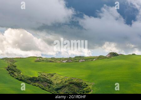 Valley with fields on the hillside in a beautiful landscape with storm clouds Stock Photo