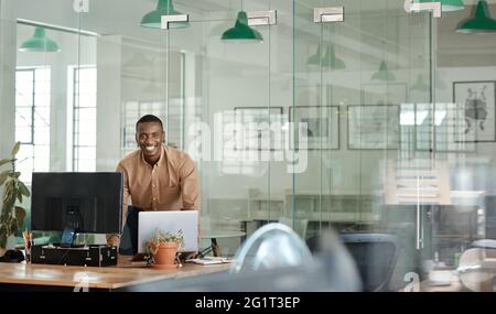 Smiling African businessman working over his desk in an office Stock Photo