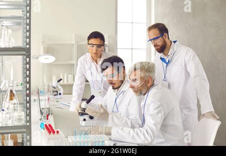 Diverse scientist group brainstorming discussing research report at laboratory Stock Photo