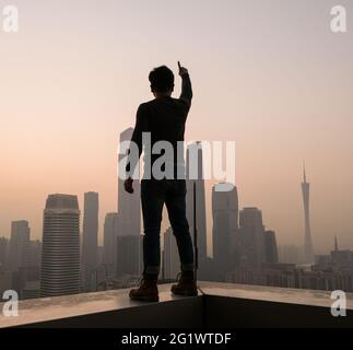 Young man with backpack looking at Beijing skyline Stock Photo