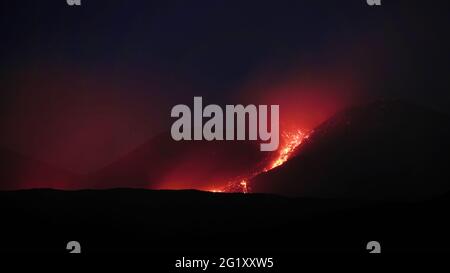 lava flow of Etna Volcano active in Sicily eruption from summit crater of south-east in the night Stock Photo