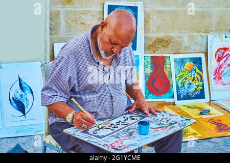 CORDOBA, SPAIN - SEPTEMBER 30, 2019: The artisan creates inscription with black ink and qalam reed pen in technique of Arabic calligraphy, on Septembe Stock Photo