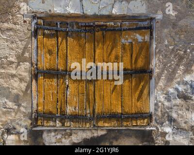 Old painted oak window shutters with ornate iron hinges - Beaulieu-lès-Loches, Indre-et-Loire (37), France. Stock Photo