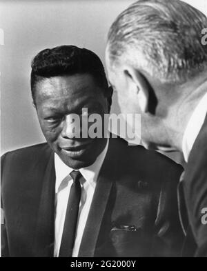 American singer-pianist Nat King Cole (1919-1965) chats with President Lyndon B Johnson (1908-1973) during Mr Cole's visit to the White House during a recent visit to Washington, DC, 1/9/1964. (Photo by Yoichi Okamoto/White House Photo Collection/RBM Vintage Images) Stock Photo
