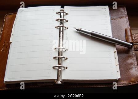 high angle view of Filofax notebook with gunmetal fountain pen Stock Photo