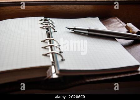 high angle view of Filofax notebook with gunmetal fountain pen Stock Photo