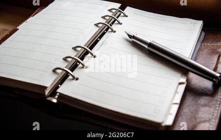 high angle view of Filofax notebook with gunmetal fountain pen Stock Photo