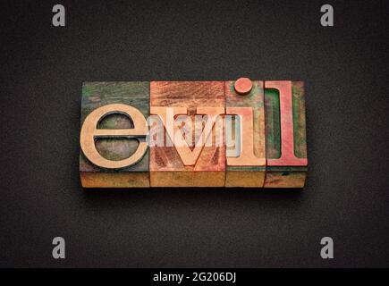 evil word abstract in vintage letterpress wood type, religious and ethical concept Stock Photo