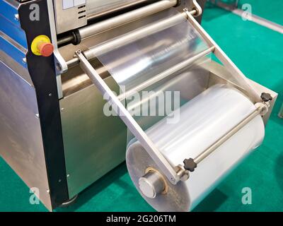 Roll of packaging film on the machine food factory Stock Photo