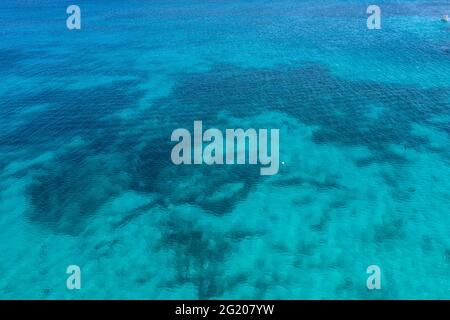 Green emerald color clear sea water background, rippled surface, aerial drone view. Small Cyclades seascape. Aegean greek islands summer vacations des Stock Photo