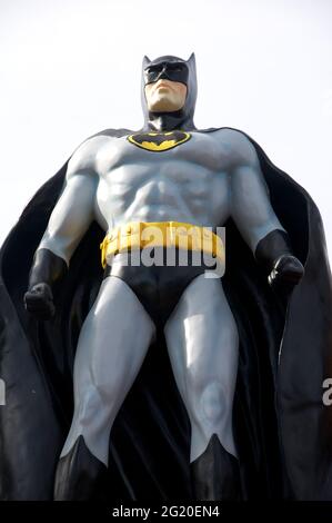 Figure of DC Comics superhero character Batman aka The Caped Crusader. created by Bob Kane and Bill Finger. Displayed in a suburban front garden. UK. Stock Photo