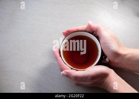 Hands holding a teacup. Copy space. Relaxing teatime. Stock Photo
