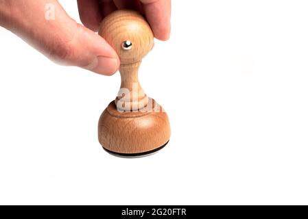 close-up of hand holding round wooden rubber stamp against white background template Stock Photo