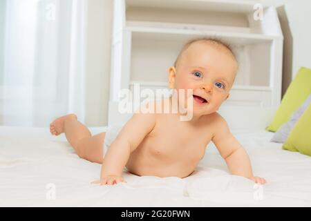 Smiling little baby lay on the belly and laugh Stock Photo