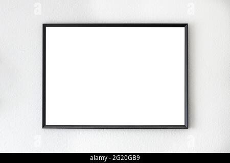 Mockup frame in black hanging on a white wall Stock Photo