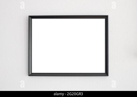 Mockup frame in black hanging on a white wall Stock Photo