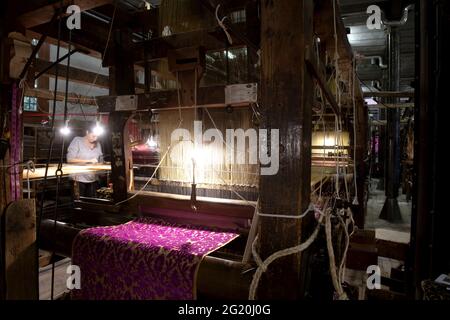 Traditional Bevilacqua weavers workshop, handycraft women work on more than 200 years old wooden loom weavings, in Venice since 1875 . Stock Photo