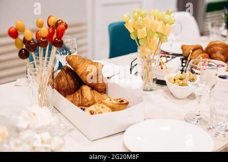 Party catering. Festive dinner table setting with canapes, croissants, different snacks for celebrating event Stock Photo