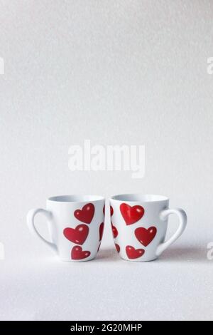 Two cute cups with hearts, shiny bright background, decorative layout, love  concept, romantic mood, place for text Stock Photo - Alamy