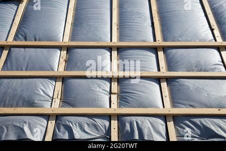 New roof coverings with insulation, isolation tiled roof, house renovation close-up background of insulation Stock Photo