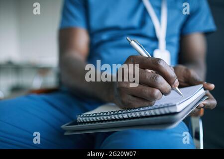 Close up of unrecognizable African-American doctor taking notes while attending medical conference or seminar, copy space Stock Photo