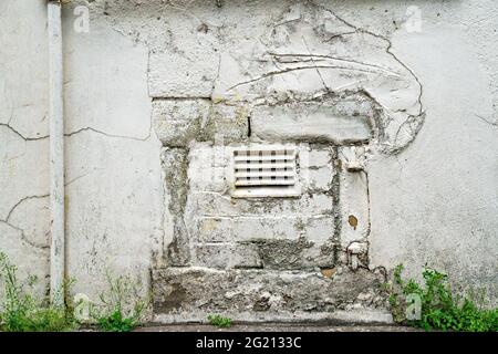 Bricked and roughly plastered finish blocking low street doorway in wall Stock Photo