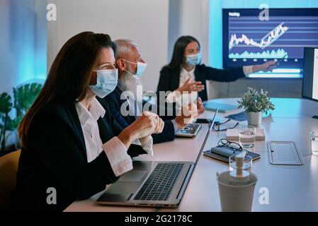 A person sitting at a desk in front of a laptop Stock Photo