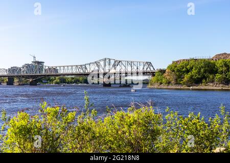 Canada, Ottawa - May 23, 2021: Panoramic view of Ottawa River and Alexandra Bridge from Ottawa to Gatineau city of Quebec, Canada on a sunny summer da