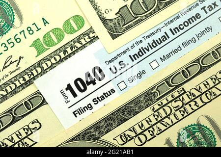 Tax forms among hundred dollar bills close up, concept of tax season, time to pay Stock Photo