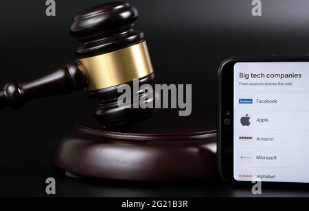 Big Tech tax regulation concept. Smartphone with the list of companies (Google definition of Big Tech) placed next to the judge gavel. Stafford, Unite Stock Photo