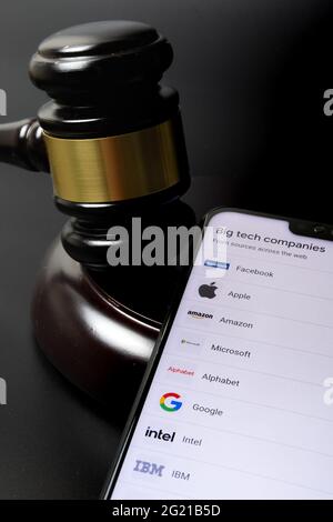 Big Tech tax regulation concept. Smartphone with the list of companies (Google definition of Big Tech) placed next to the judge gavel. Stafford, Unite Stock Photo