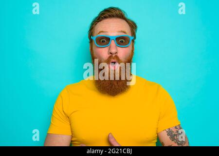Man with beard and sunglasses is wondered and happy Stock Photo
