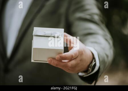 man giving a present in a gift box close up Stock Photo