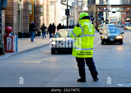 A City of Chicago Office of Emergency Management and Communications worker observes traffic on a busy downtown street in Chicago, Illinois, USA.