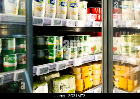 Yogurts in supermarket fridge Stock Photo