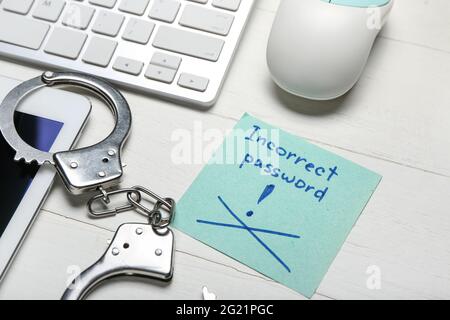 PC keyboard, handcuffs and paper with text INCORRECT PASSWORD on white background. Hacking concept Stock Photo
