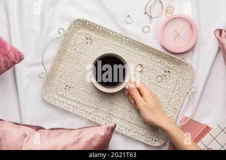 Woman with cup of coffee on bed Stock Photo