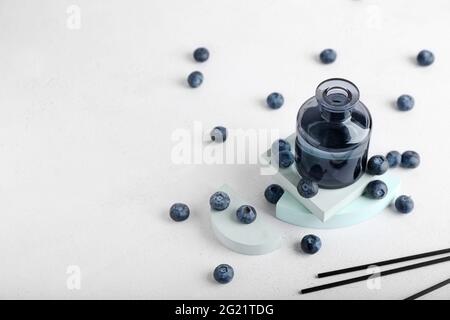 Reed diffuser with blueberries on white background Stock Photo
