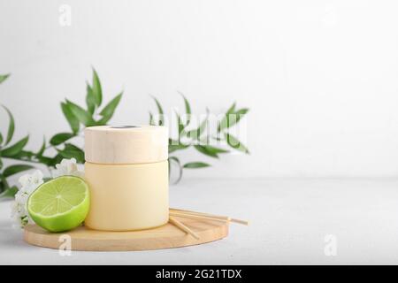 Reed diffuser with lime and flowers on light background Stock Photo