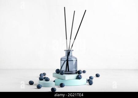 Reed diffuser with blueberries on white background Stock Photo