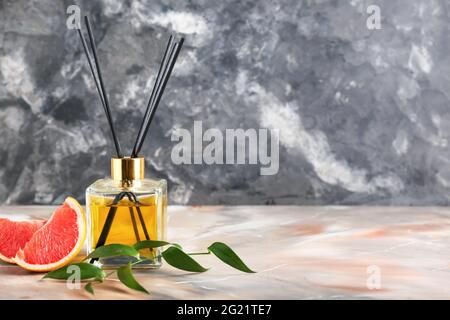 Reed diffuser with grapefruit on grunge background Stock Photo