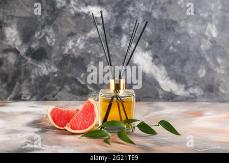 Reed diffuser with grapefruit on grunge background Stock Photo