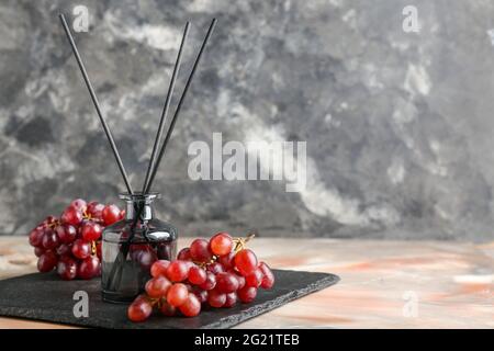 Reed diffuser with grapes on grunge background Stock Photo
