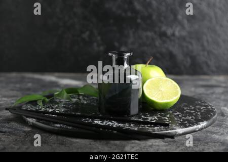 Reed diffuser with fruits on dark background Stock Photo